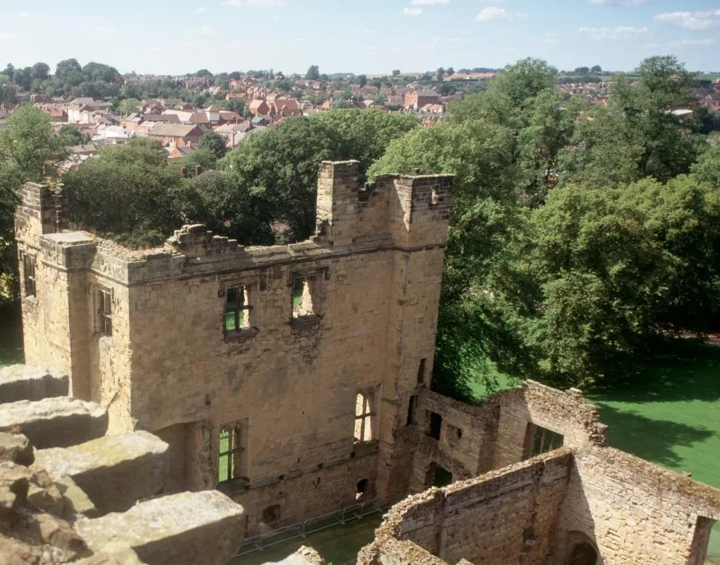 The roofless castle ruins seen from the top of the tower, with Ashby's rooftops beyond