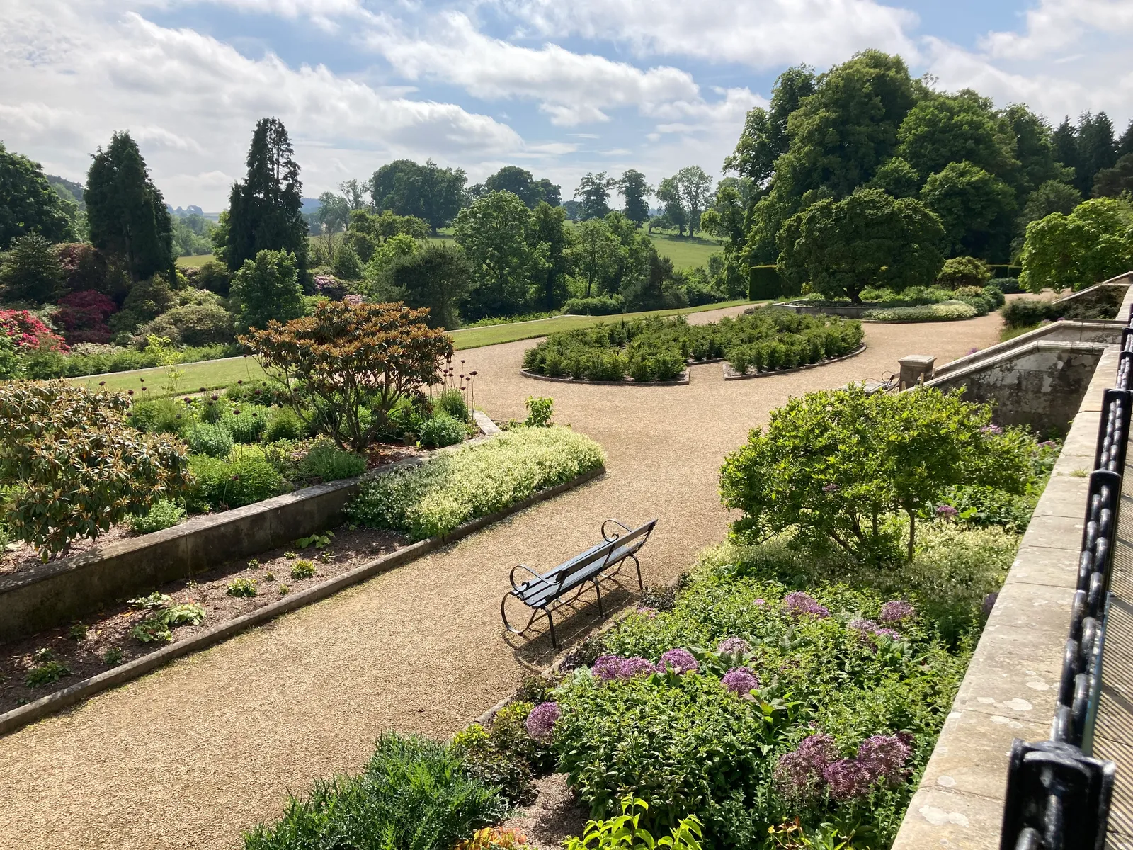 The lower terrace garden in early summer, with the parkland and rhododendrons beyond