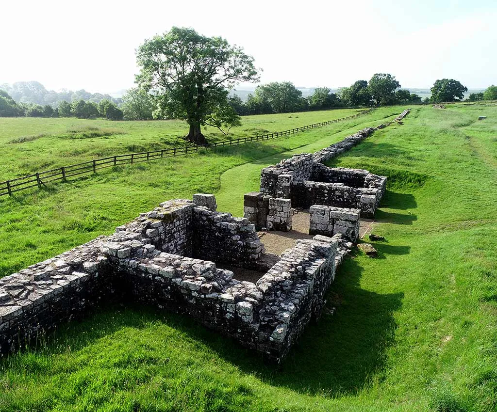 The excavated east gate of the fort and the line of the fort wall across the grass