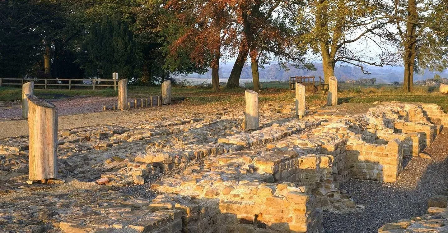 The stone floor of the north granary and timber posts in low autumn sunlight