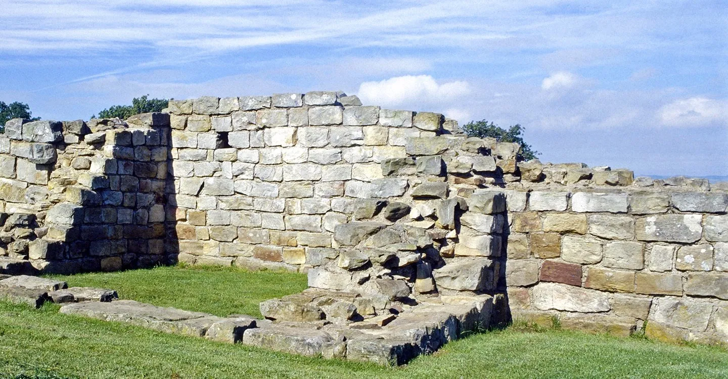 The squared sandstone walls of Black Carts Turret on Hadrian's Wall under a blue sky with wispy cloud
