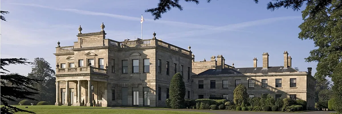 The east front with its columned porch and the service wing in autumn sunshine