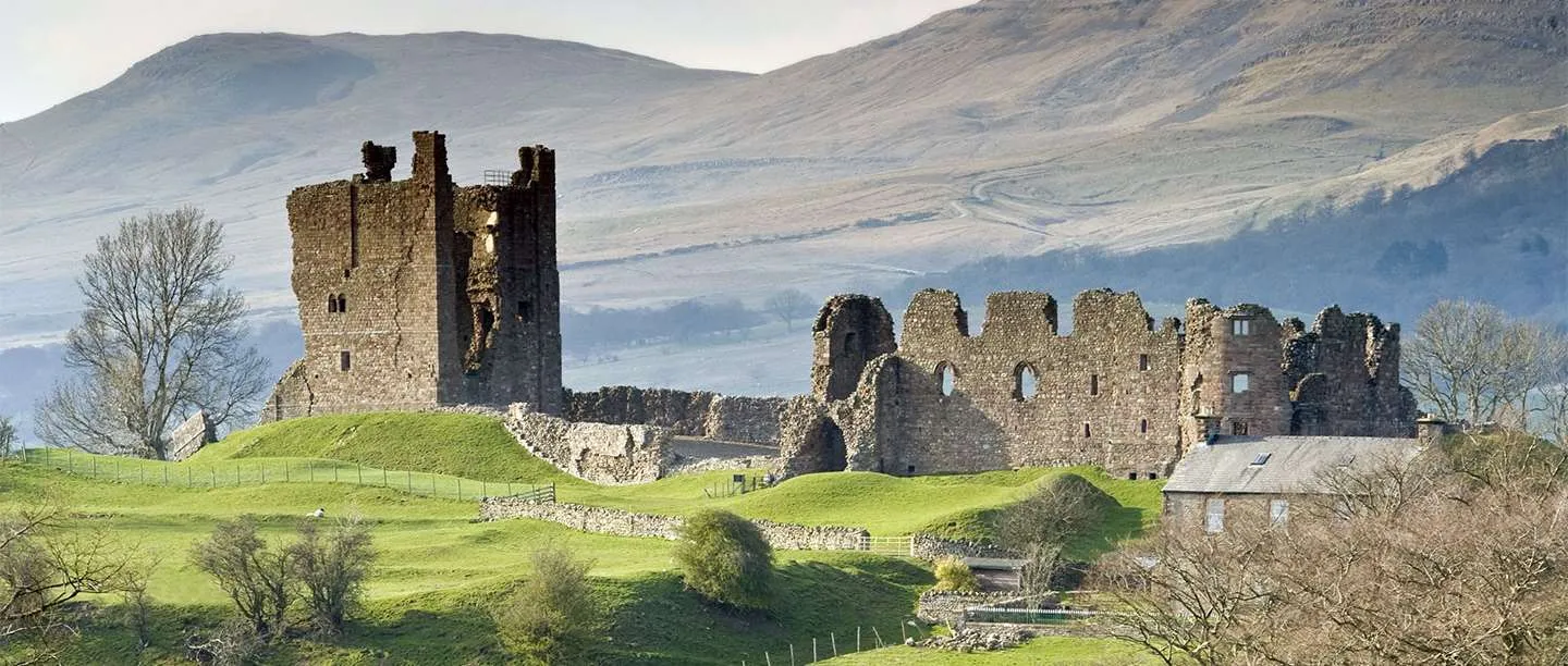 Brough Castle's ruined keep and hall range on their grassy mound, with the Pennine fells behind