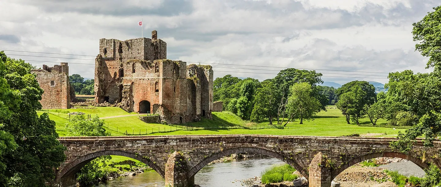 The keep of Brougham Castle beyond the stone arches of Brougham Bridge