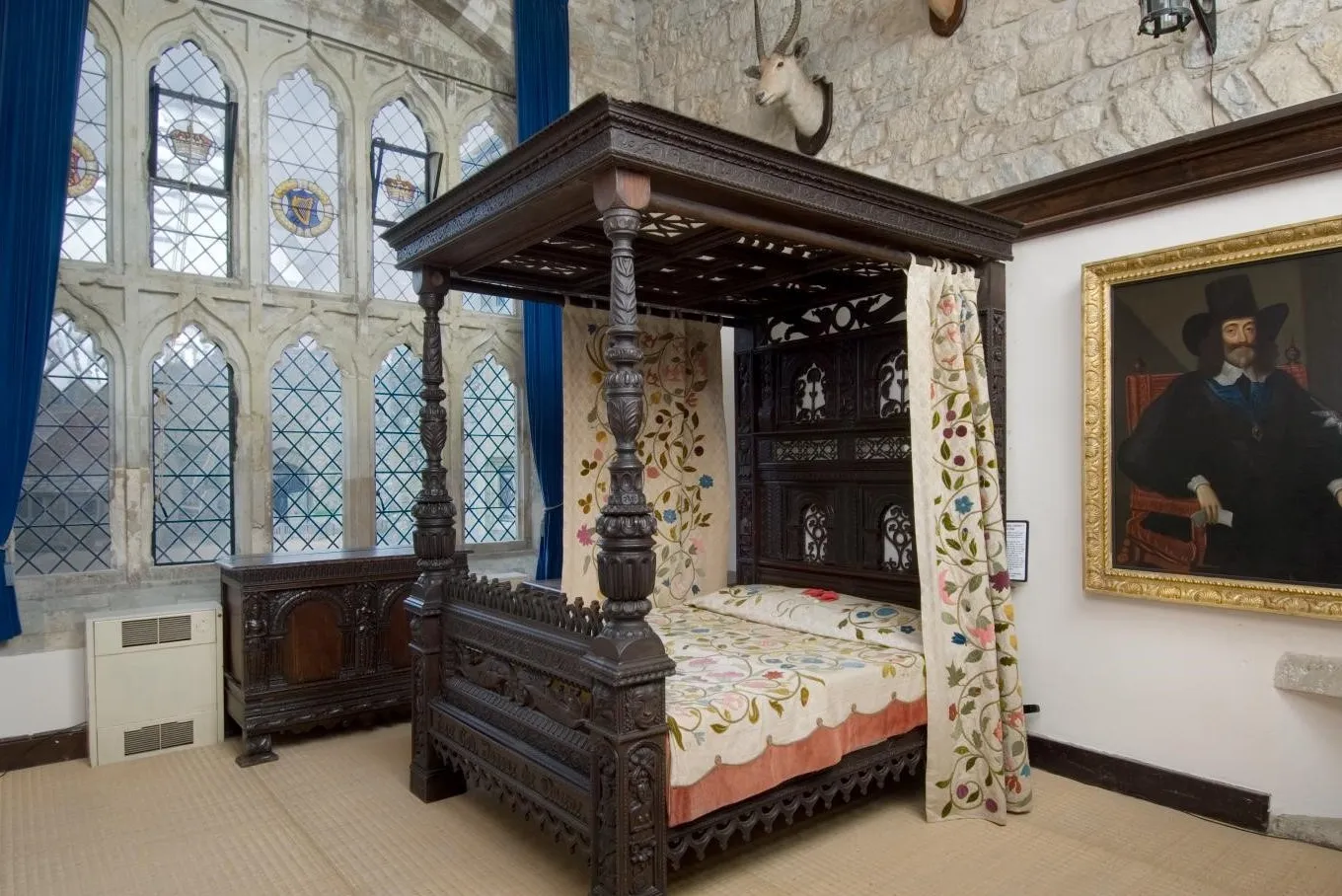 A carved four-poster bed with embroidered hangings in Charles I's bedroom