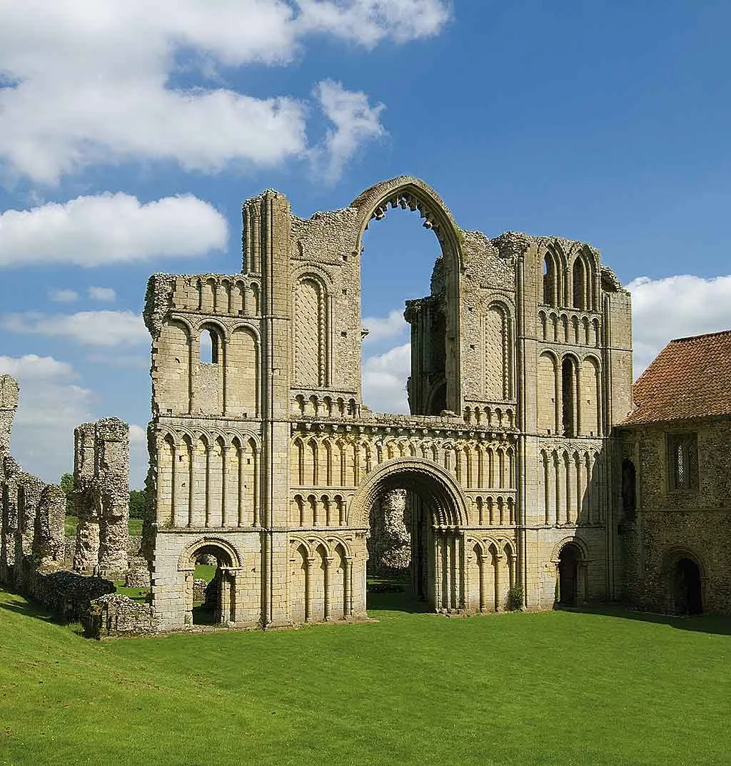 The west front of the priory church with its great Gothic window arch against a blue sky