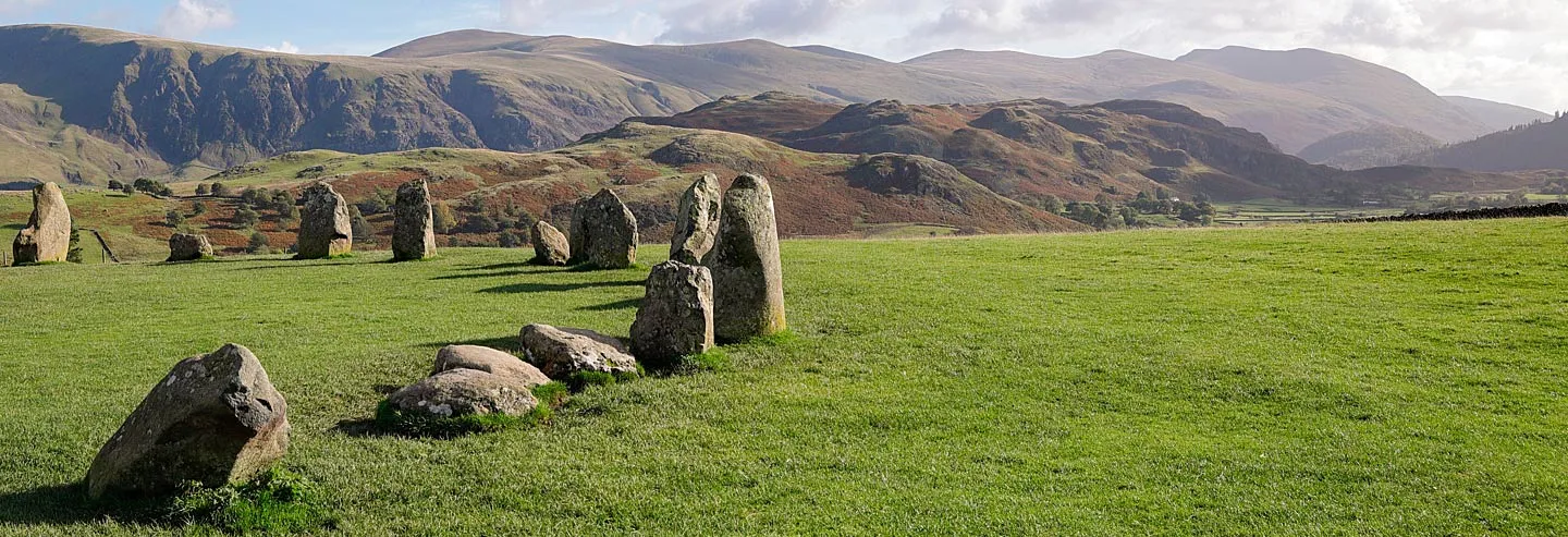 Stones of the circle in autumn light with the fells behind