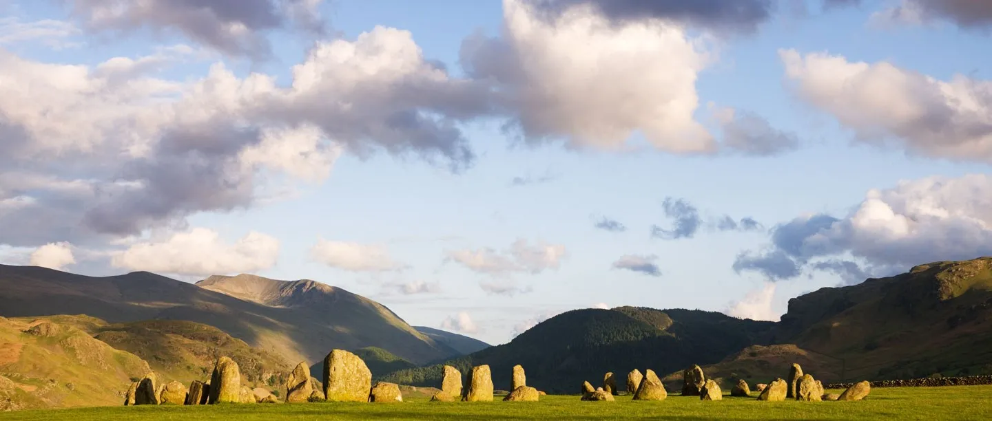 A wide view of the circle in a ring of Lakeland mountains under a summer sky