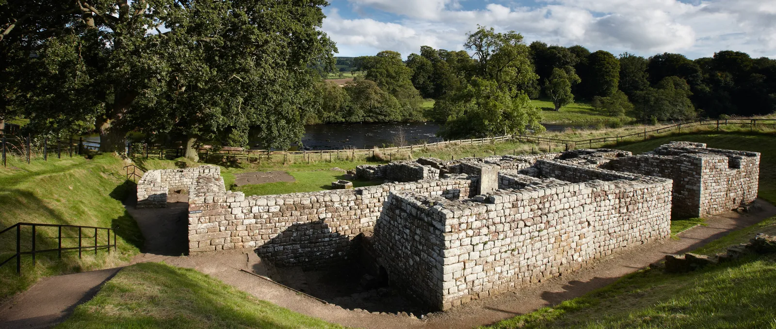 The Roman bathhouse beside the River North Tyne in afternoon sun
