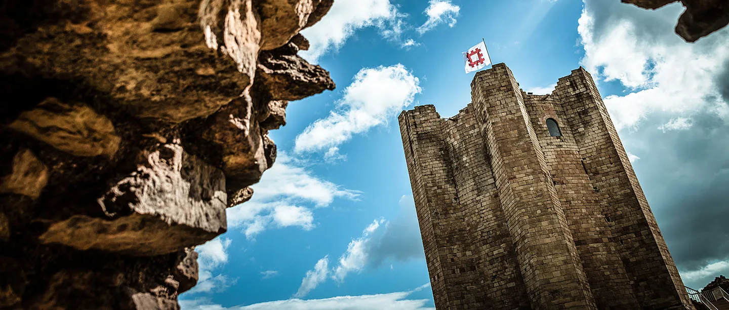 The keep and its English Heritage flag framed by the ruined curtain wall