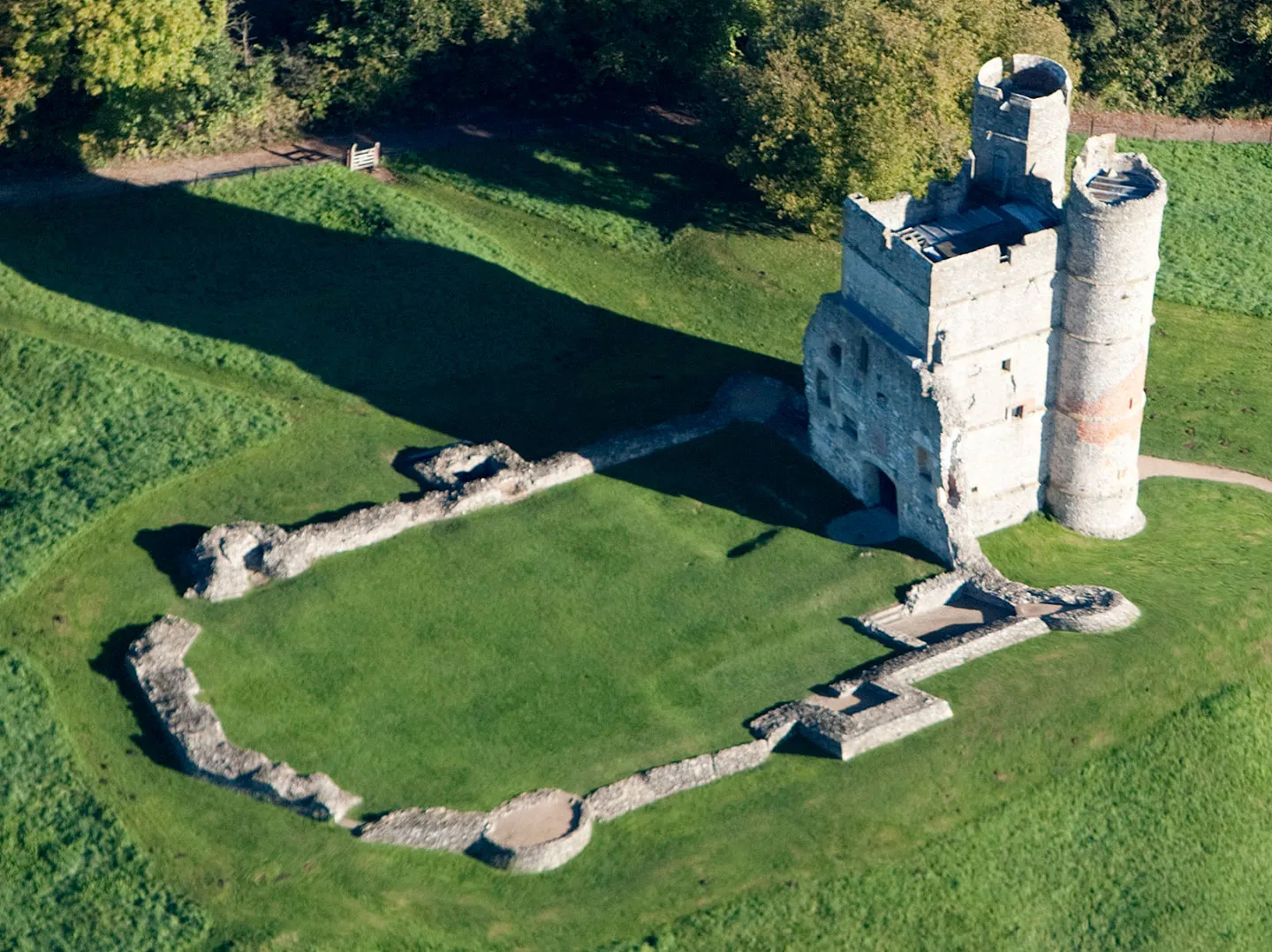 Looking down on the gatehouse and the outline of the castle walls on the grassy hilltop