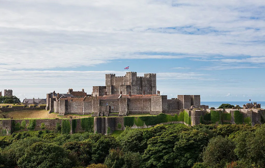 Dover Castle's great tower and curtain walls above the trees, with the sea beyond