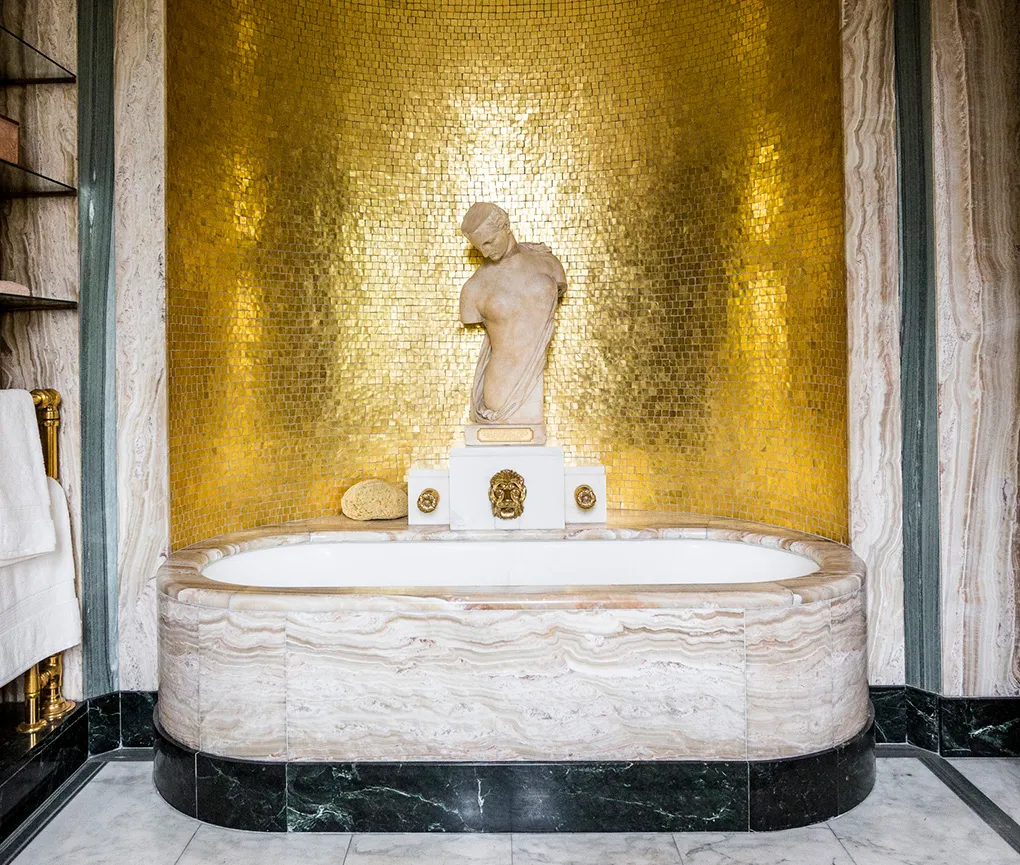 The gold mosaic bath alcove with its onyx bath and statue
