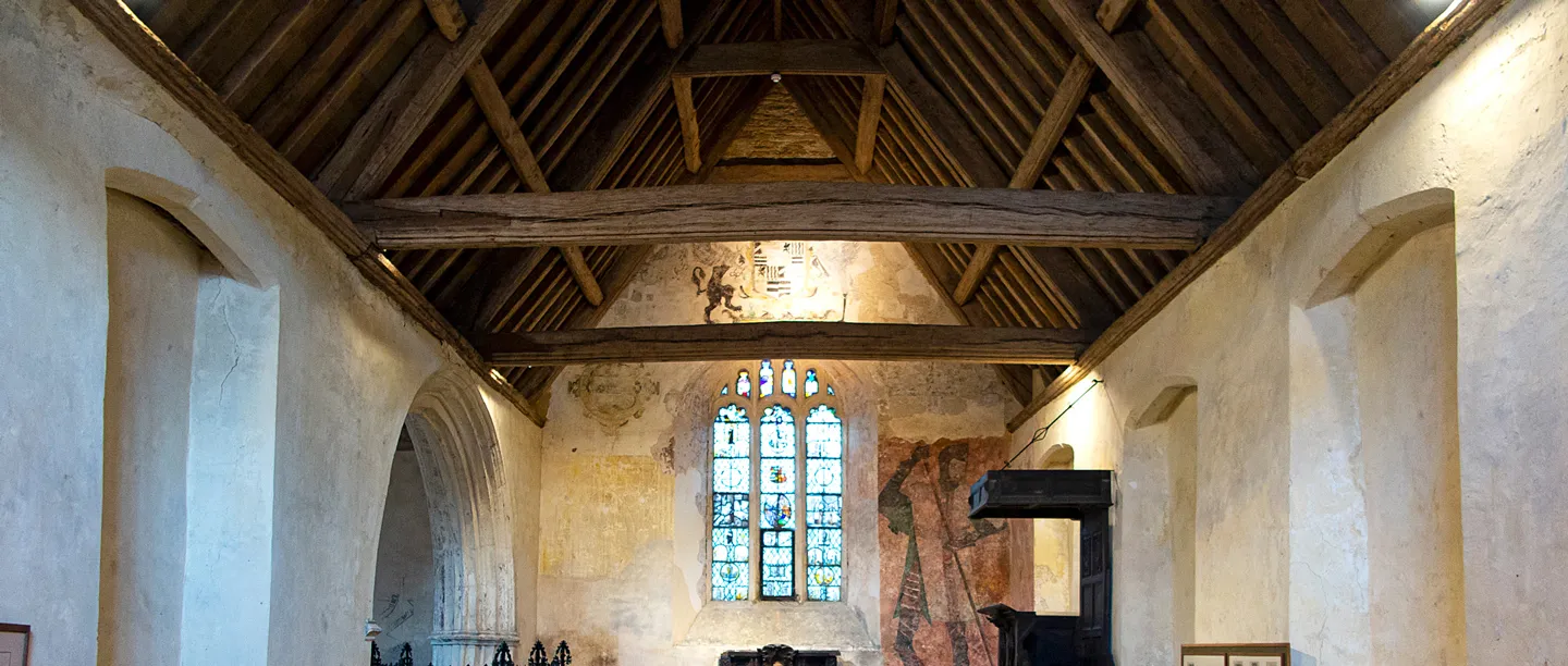 Inside St Leonard's Chapel at Farleigh Hungerford: timber roof, stained glass and a medieval wall painting