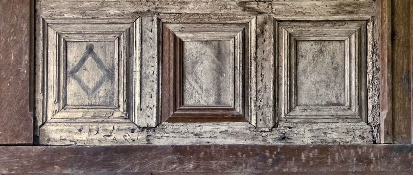 Weathered oak panelling with a painted diamond inside Fiddleford Manor
