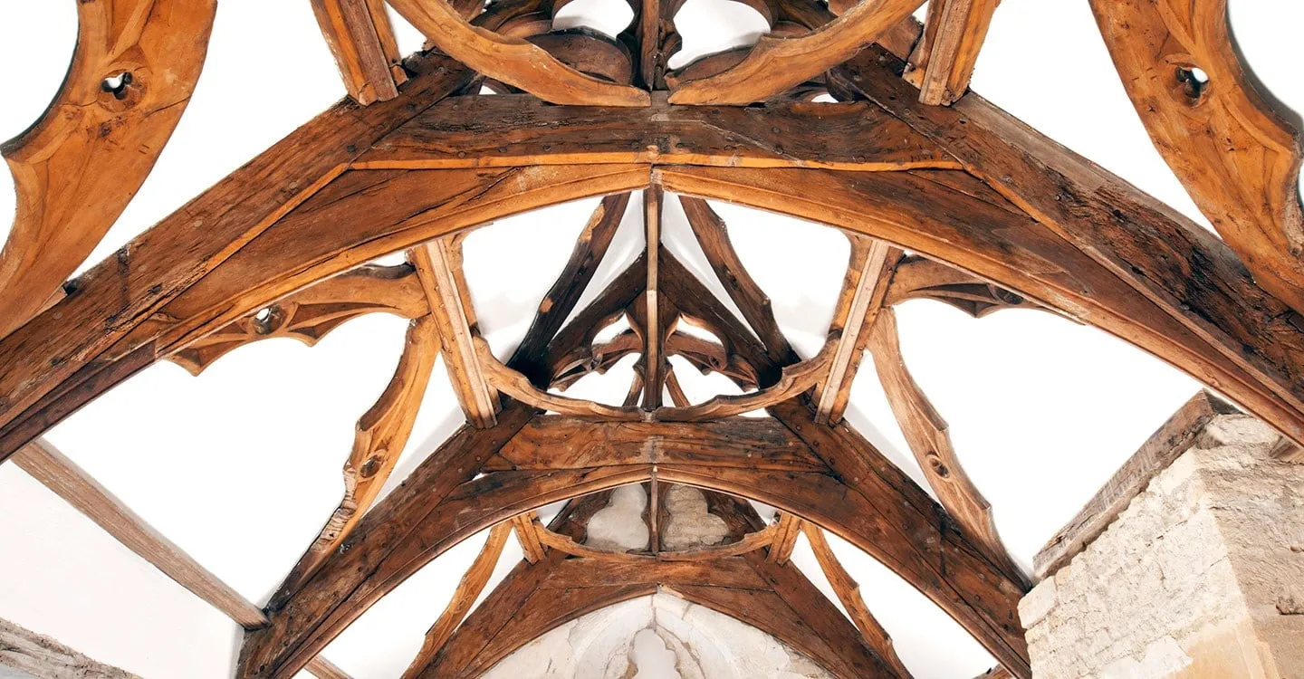The elaborate arch-braced timber roof of Fiddleford Manor's hall, with cusped wind-braces