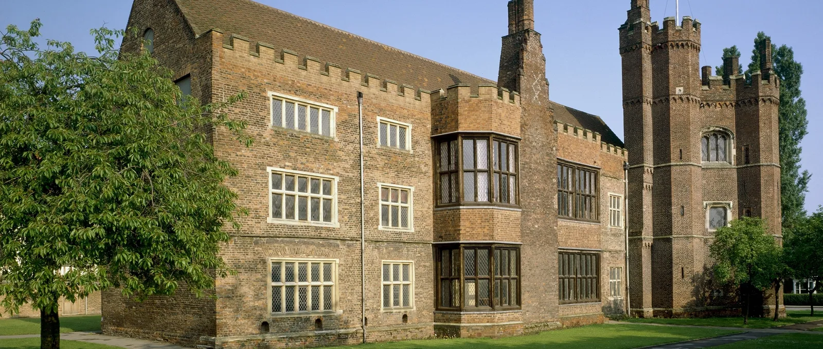 The brick east range and the tall battlemented tower of Gainsborough Old Hall in evening sun