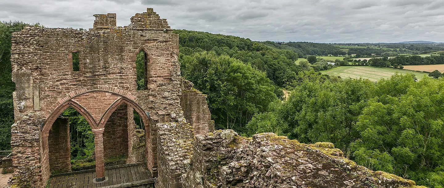 Twin pointed arches in the ruined solar block, with the wooded Wye valley beyond