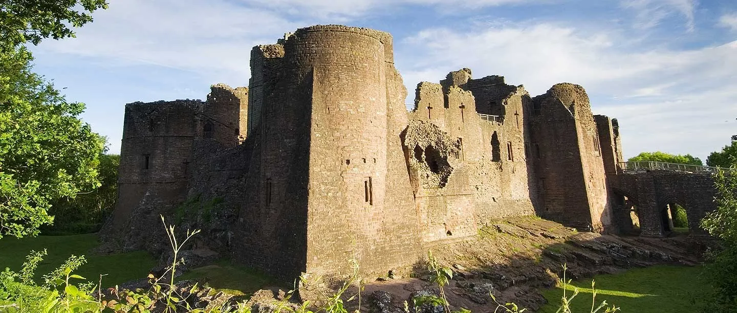 The red sandstone towers rising from the rock-cut ditch in evening light