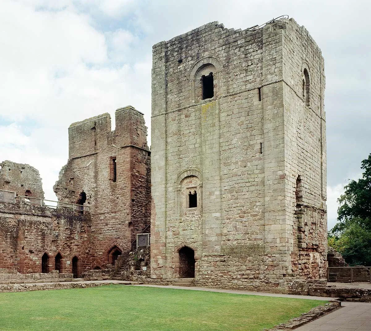 The pale Norman keep beside the red sandstone ranges of the courtyard