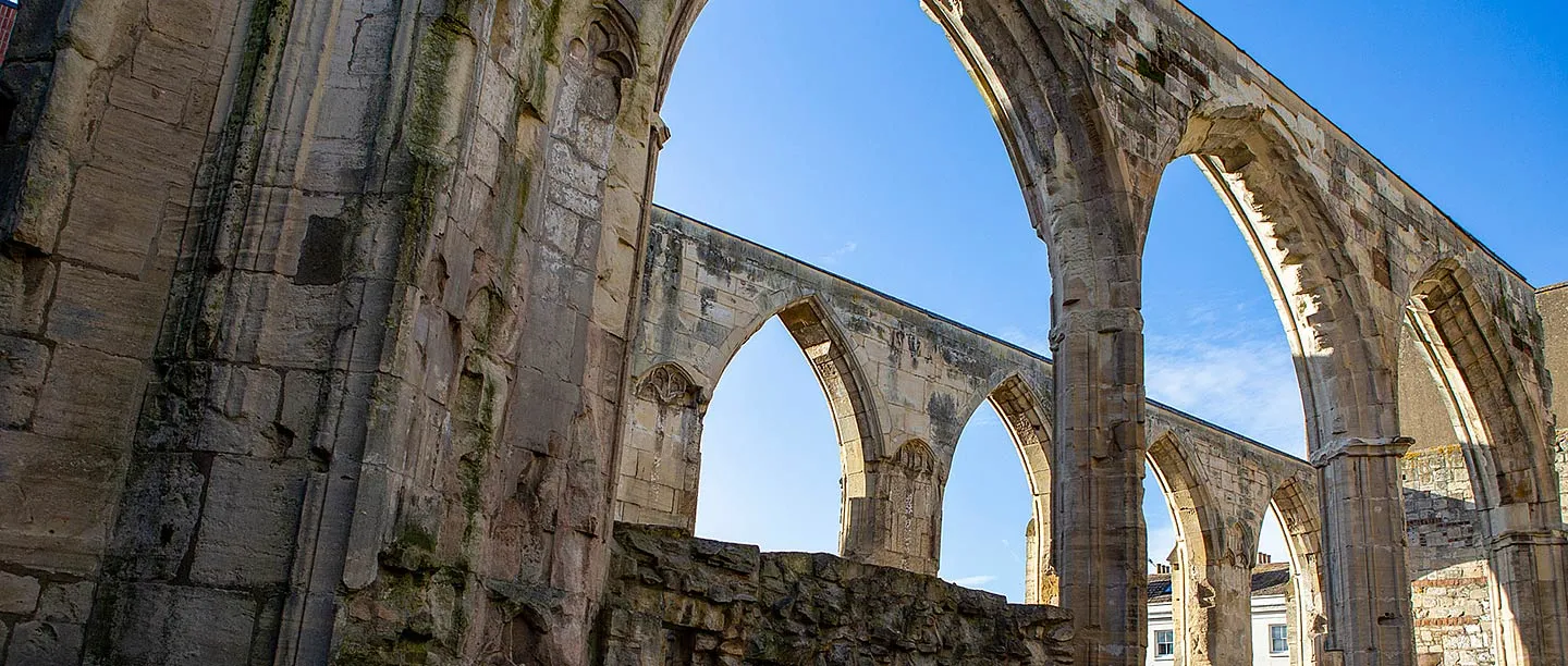 The soaring pointed arches of the ruined Greyfriars church in Gloucester against a deep blue sky