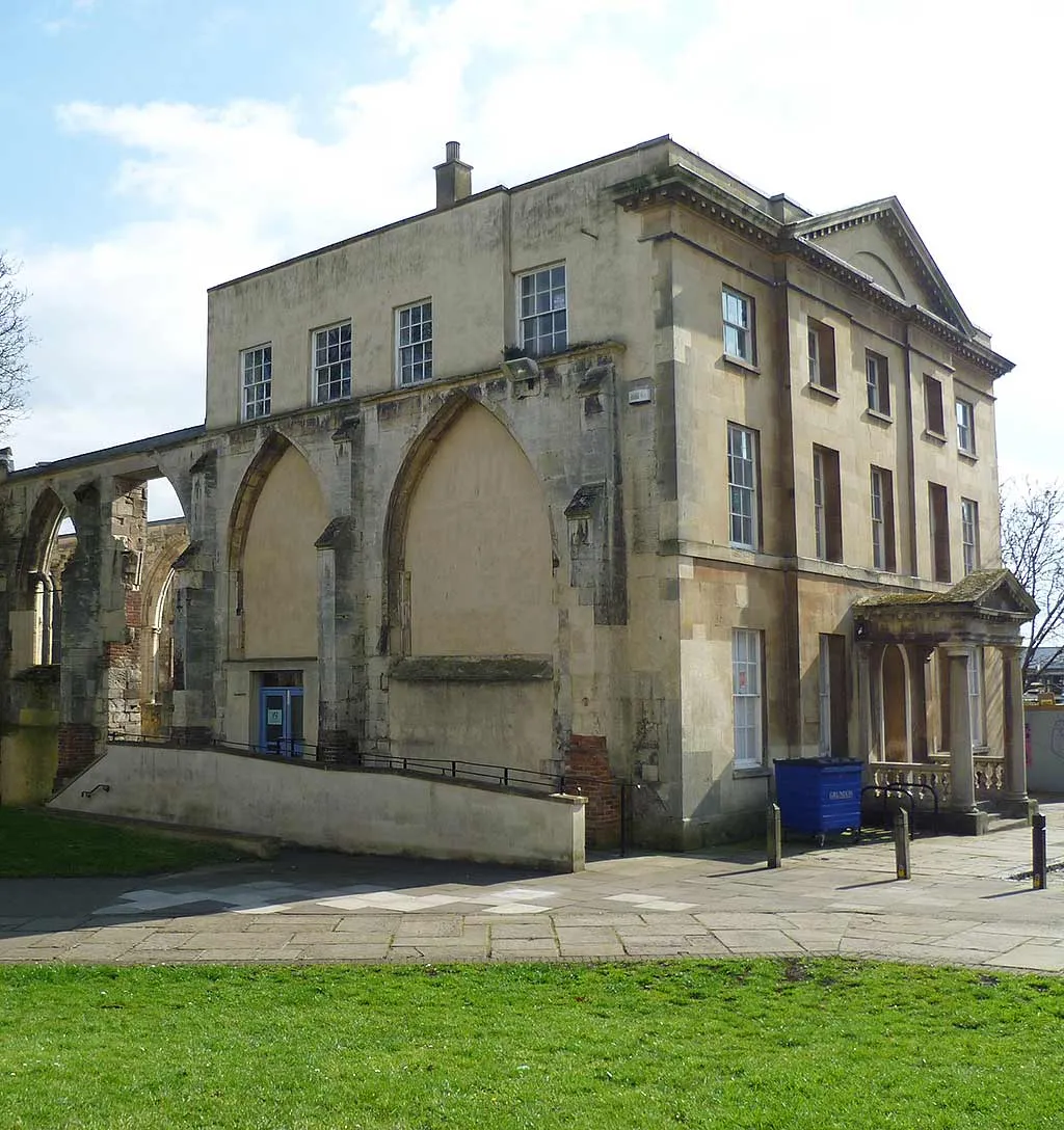 The Georgian house built into the ruined arches of Greyfriars, Gloucester, beside a paved square and lawn