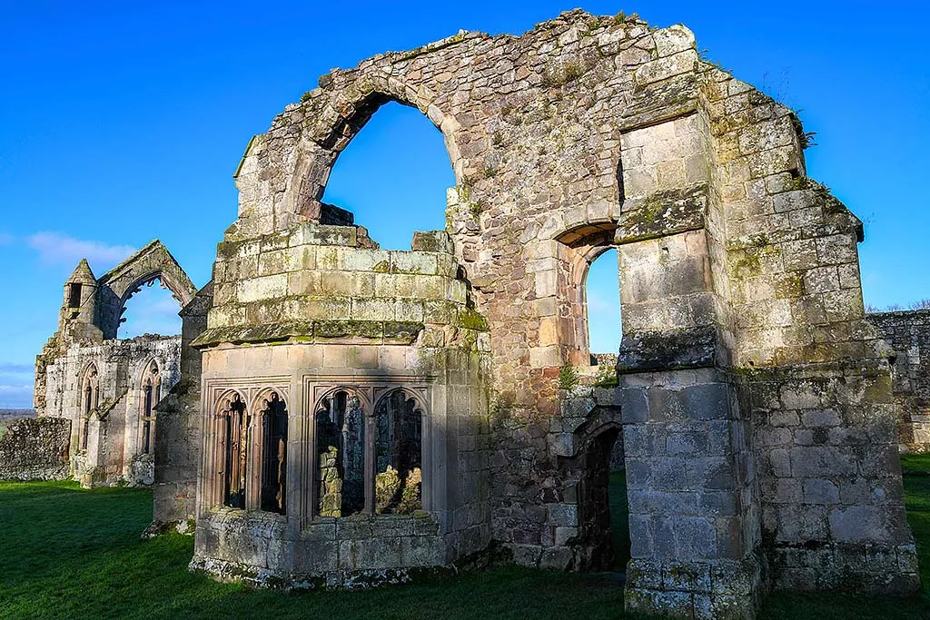 The ruined bay window and great arch of the abbot's hall at Haughmond Abbey under a deep blue winter sky
