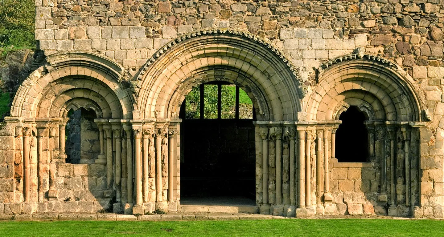 Carved Norman arches of the chapter house front at Haughmond Abbey, with saints carved on the shafts