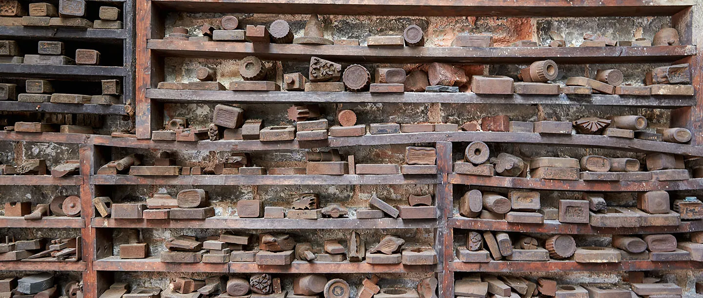 Wooden racks stacked with hundreds of steel stamping dies at the JW Evans Silver Factory