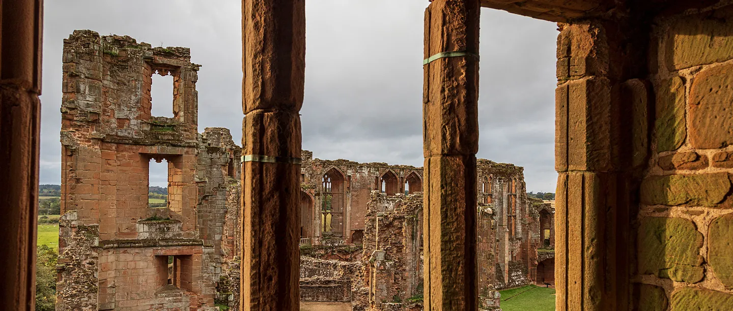 The ruins seen through a stone window in Leicester's Building