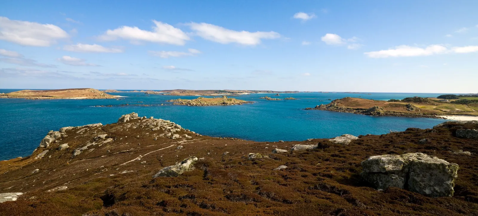 The view from King Charles's Castle over turquoise water to the low islands of the Isles of Scilly