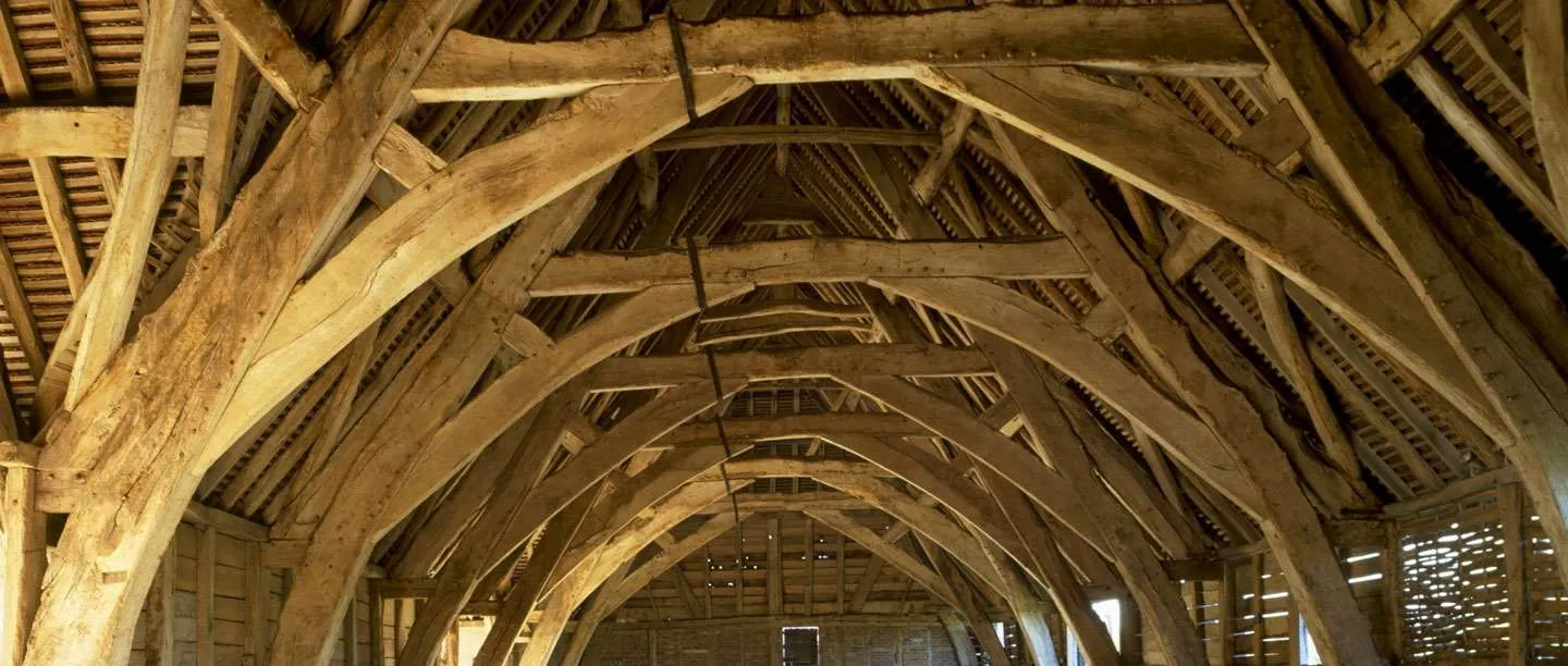 The huge oak cruck frames of Leigh Court Barn arching in a long row beneath the roof