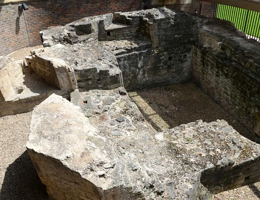 Stone remains of the medieval postern gate beside London Wall, in a sunken court by Tower Hill