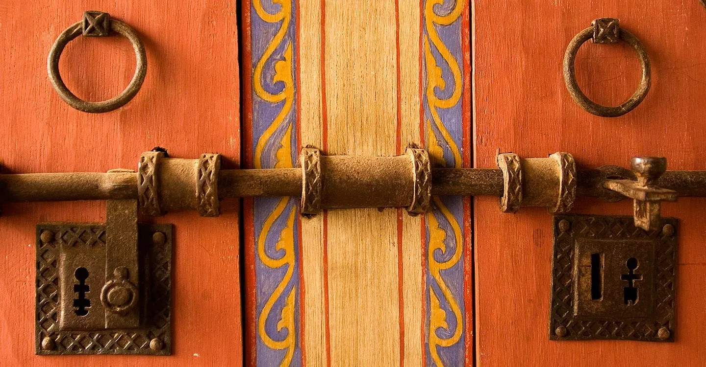 Painted wooden shutters with iron rings, lock plates and a long iron bolt at the Medieval Merchant's House