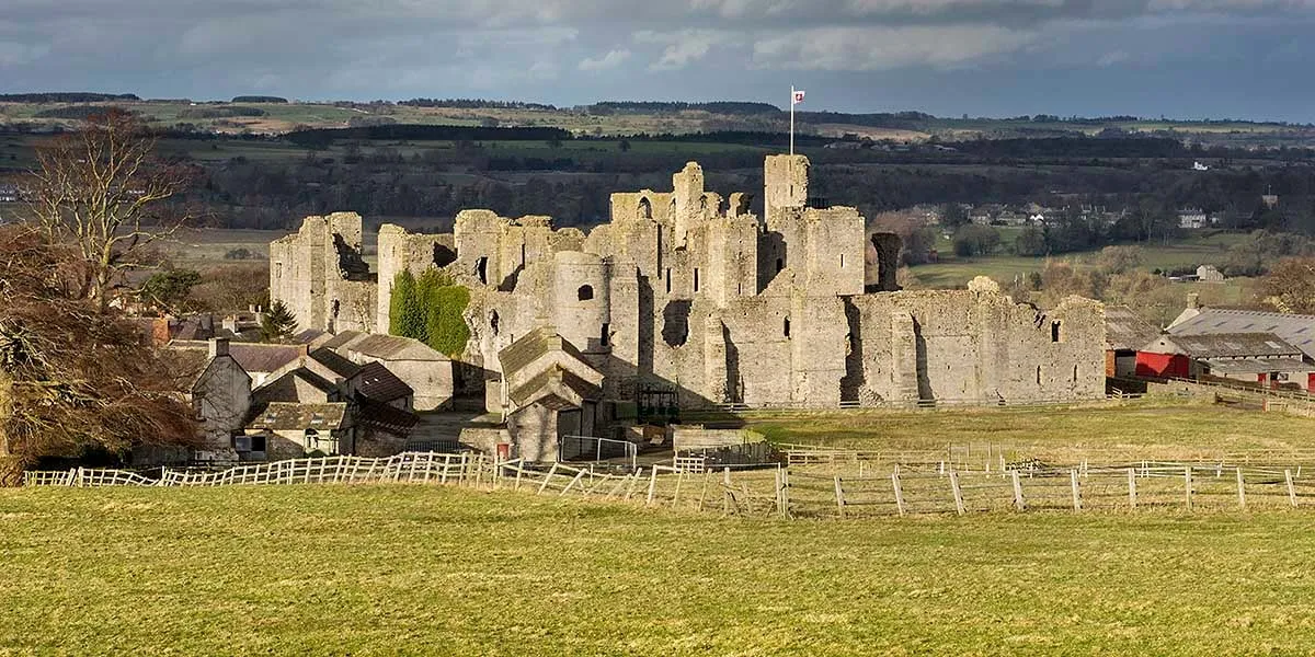 Middleham Castle rising behind the village roofs, with the dale beyond