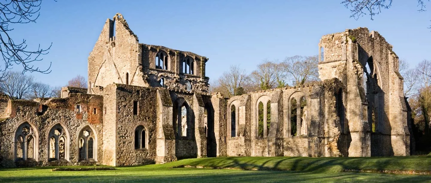 Netley Abbey's roofless church and south transept in winter sunshine, seen across the lawn