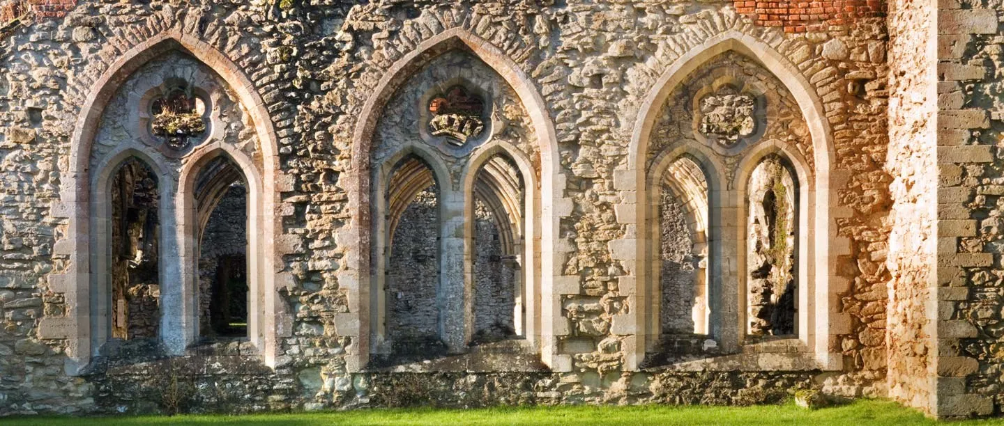 Pointed traceried windows set in the flint and stone walls of Netley Abbey