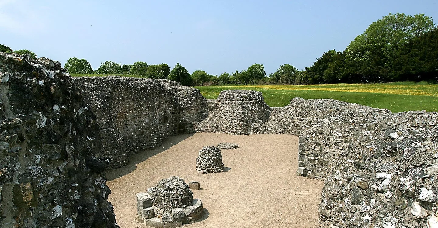 Flint walls of the inner bailey courtyard ruins under a clear blue sky