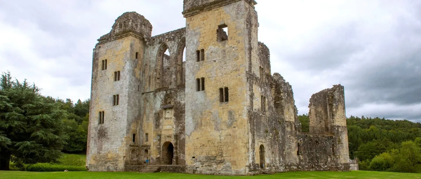 The entrance front of Old Wardour Castle with its steps and great arched doorway under a grey sky