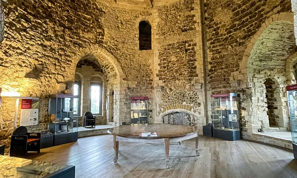 The keep's upper hall with Norman window arches, display cases and a round table