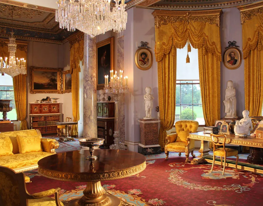 The drawing room with its yellow damask, marble columns and chandeliers