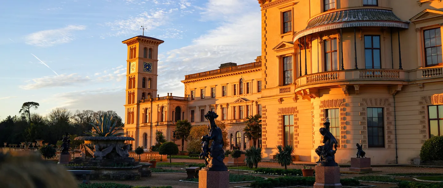 The house glowing in low winter sun beyond the terrace statues
