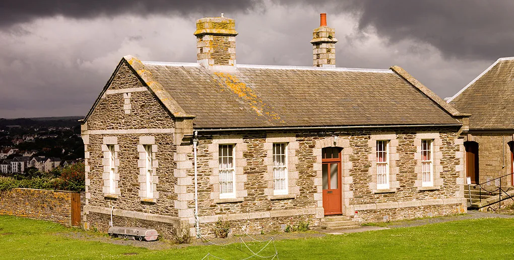 Stone cottages within the castle walls under a dark stormy sky