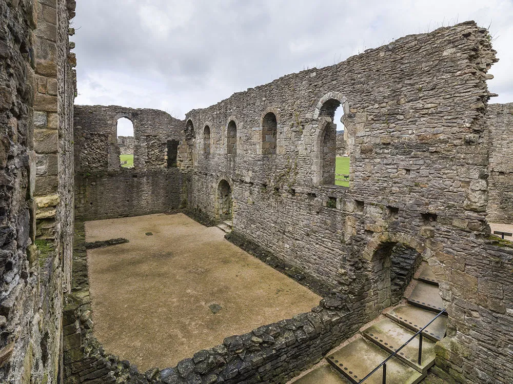 Inside the roofless shell of Scolland's Hall, with its round-headed windows