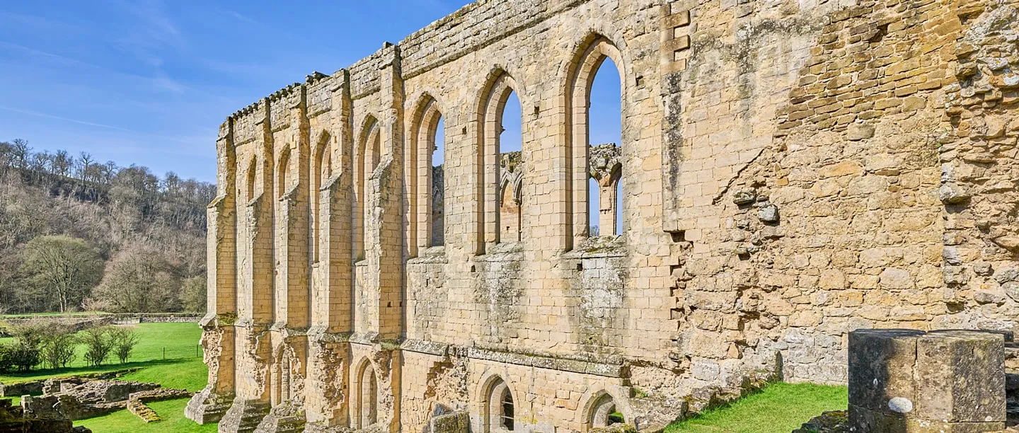 The refectory's long wall of lancet windows above the valley in spring