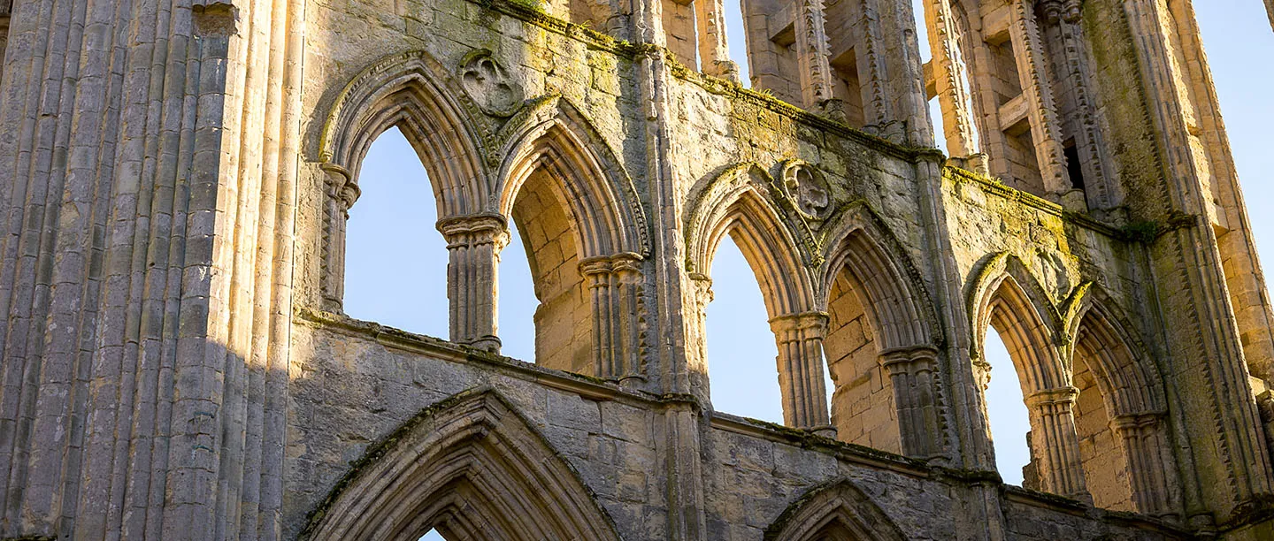 Clerestory arches and dogtooth mouldings against a blue sky