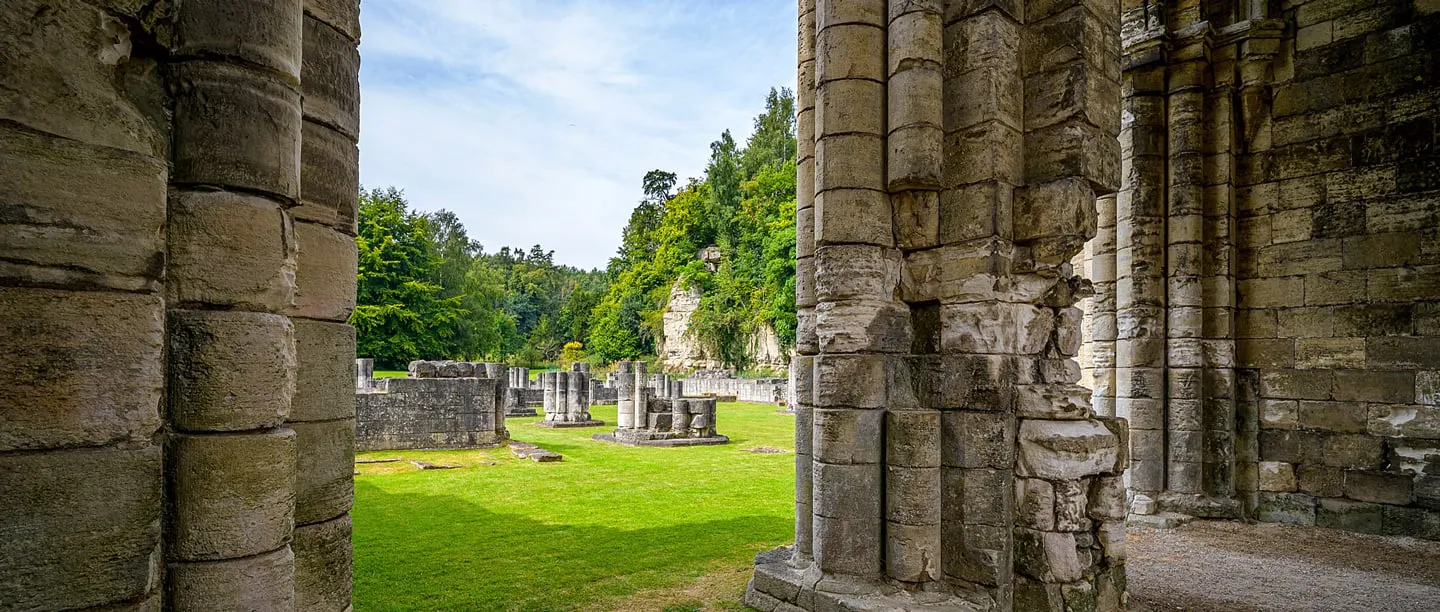 Massive clustered piers of Roche Abbey's church, with column bases and lawns beyond