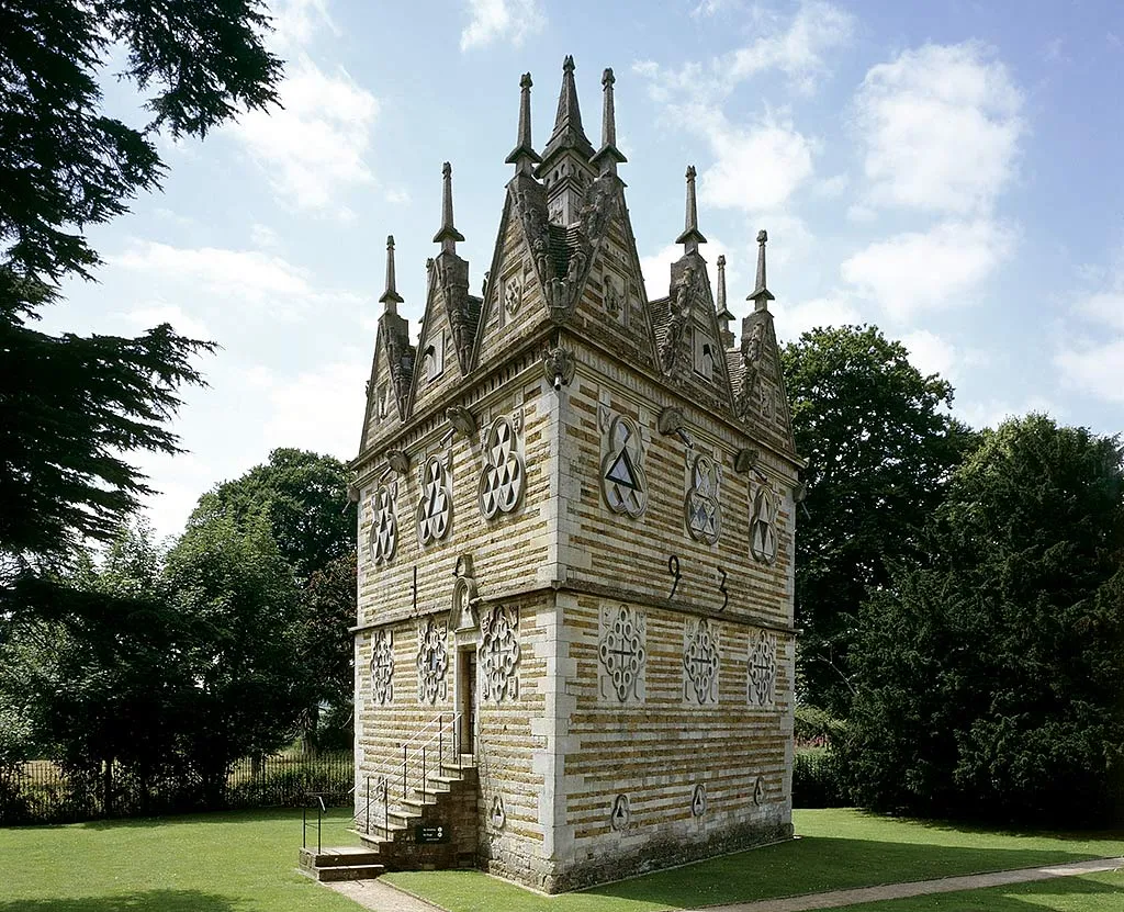 Rushton Triangular Lodge, a three-sided Elizabethan lodge of banded stone with gables and pinnacles, among trees on a lawn