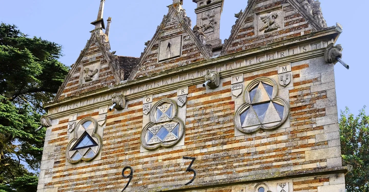 Trefoil windows, heraldic shields and a Latin inscription on the banded stone of Rushton Triangular Lodge