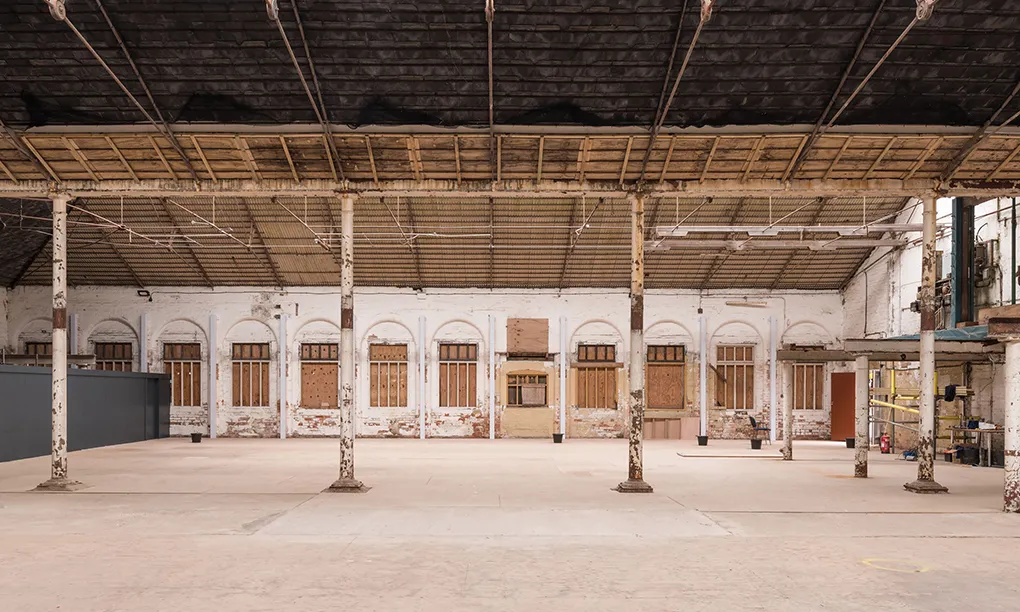 The unrestored maltings floor at Shrewsbury Flaxmill Maltings, with peeling iron columns, boarded arched windows and a timber roof